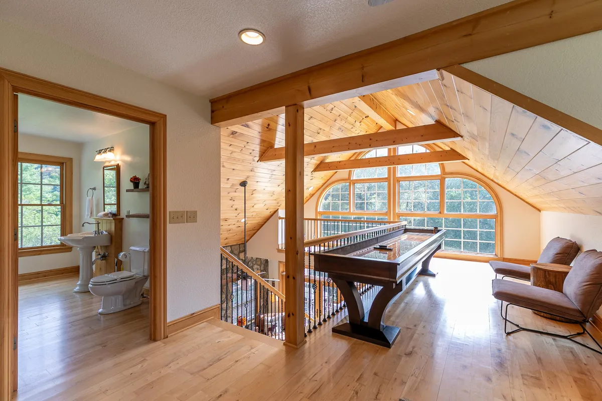 A warm and welcoming entertainment den highlighted by a pool table, comfortable seating area, and expansive windows with scenic views. The space feels both lively and cozy, set up for game nights, socializing, or simply unwinding after a day’s adventures.